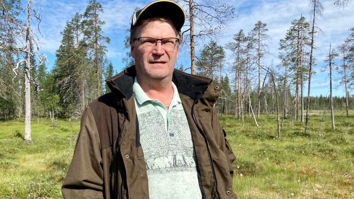 Vihreään eräasuun pukeutunut Lapin tuorelakka Oy:n toimitusjohtaja Jari Huttunen hillasuo taustanaan.