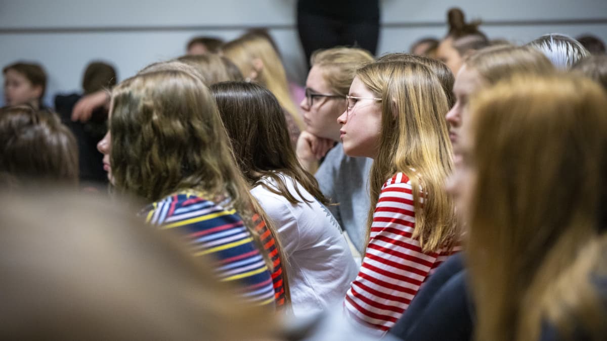 Oppilaita kuuntelemassa Jyri Paretskoita Minna Canthin koulun liikuntasalissa