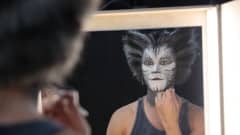 CATS-musikaalin näyttelijä meikkaa itseään.