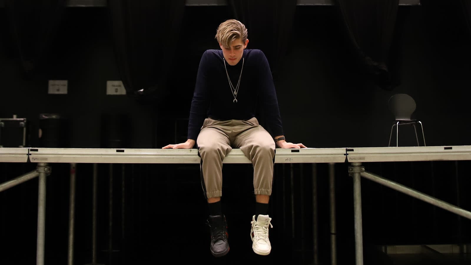 Robin Packalen istumassa tyhjällä lavalla Logomossa joulukuussa 2020. Keskitetty lähikuva.