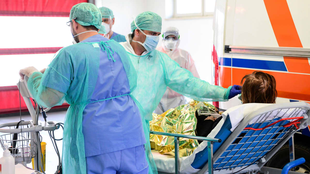 Sairaalan henkilökunta ottaa vastaan uutta koronaviruspotilasta sairaalassa Lombardiassa 17. maaliskuuta.