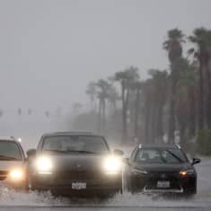 Kolme autoa ajaa tulvivassa vedessä Kaliforniassa.