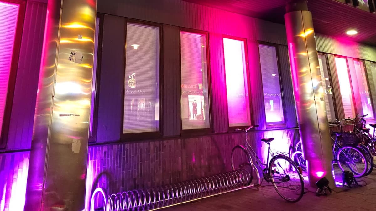 Mikkelin poliisilaitoksen seinä on valaistu pinkeillä valoilla.