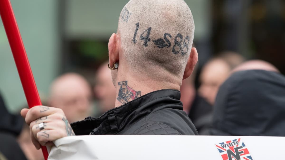 Miehen paljaaksi ajeltuun päähän on tatuoitu uusnatsien symboleja.