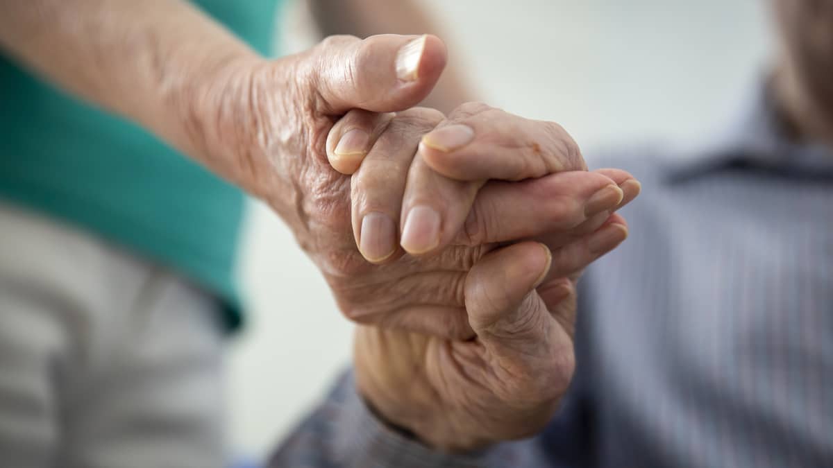 Två personer håller varandra i hand.  
