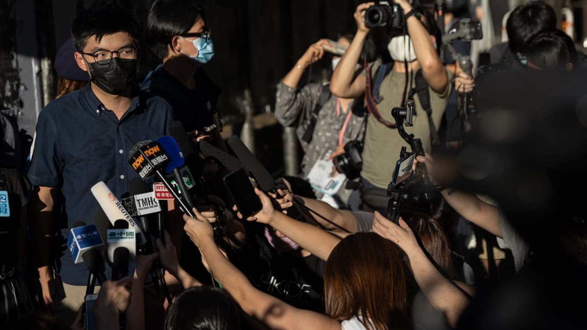 Joshua Wong toimittajien ympäröimänä