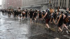 New Yorkissa ihmiset marssivat sateessa Black Lives Matter -kulkueessa.