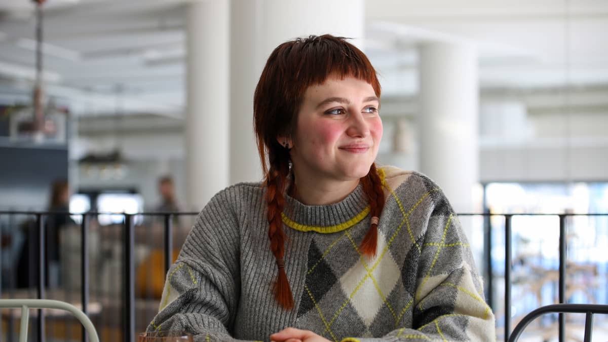 Yuliia Bielokrynytska istuu kahvilan pöydässä ja katsoo ulos ikkunasta.