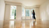 Olga Filipova kävelee tyhjän olohuoneen parketilla.