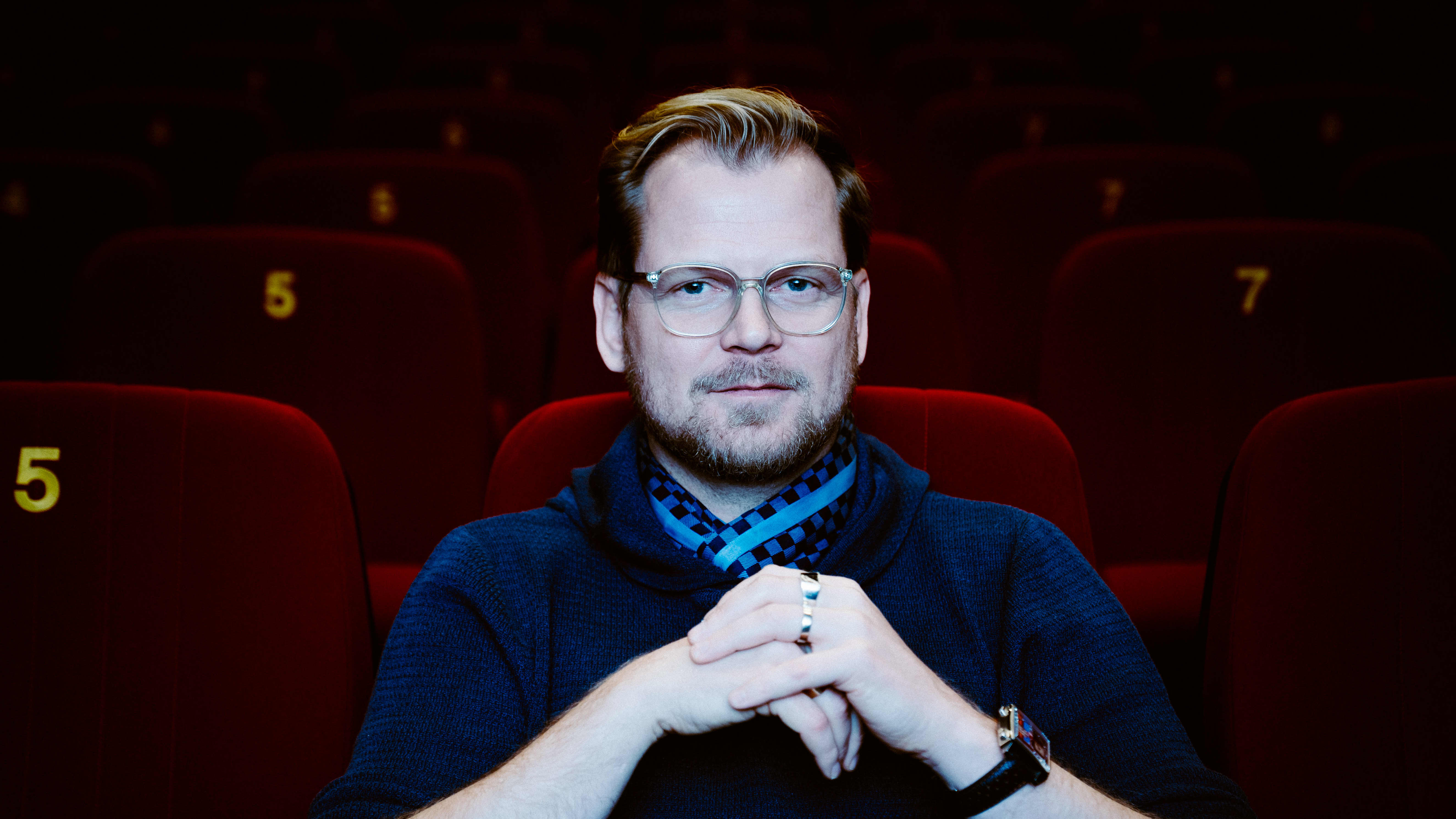 Antti Luusuaniemi istuu Kino Korjaamo elokuvateatterin salissa.