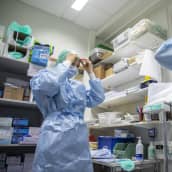 Hoitajat pukevat suojavarustuksia ylleen