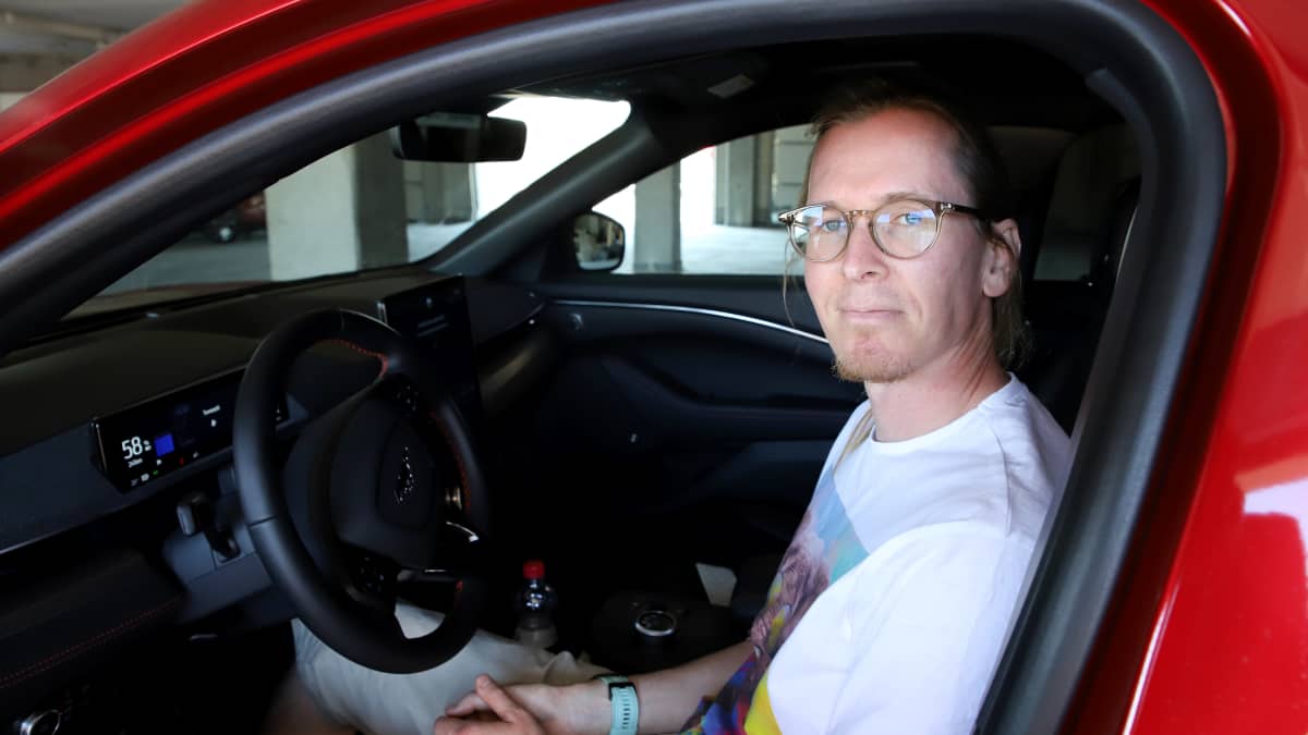 Jani Pärnänen istuu sähköautossaan.