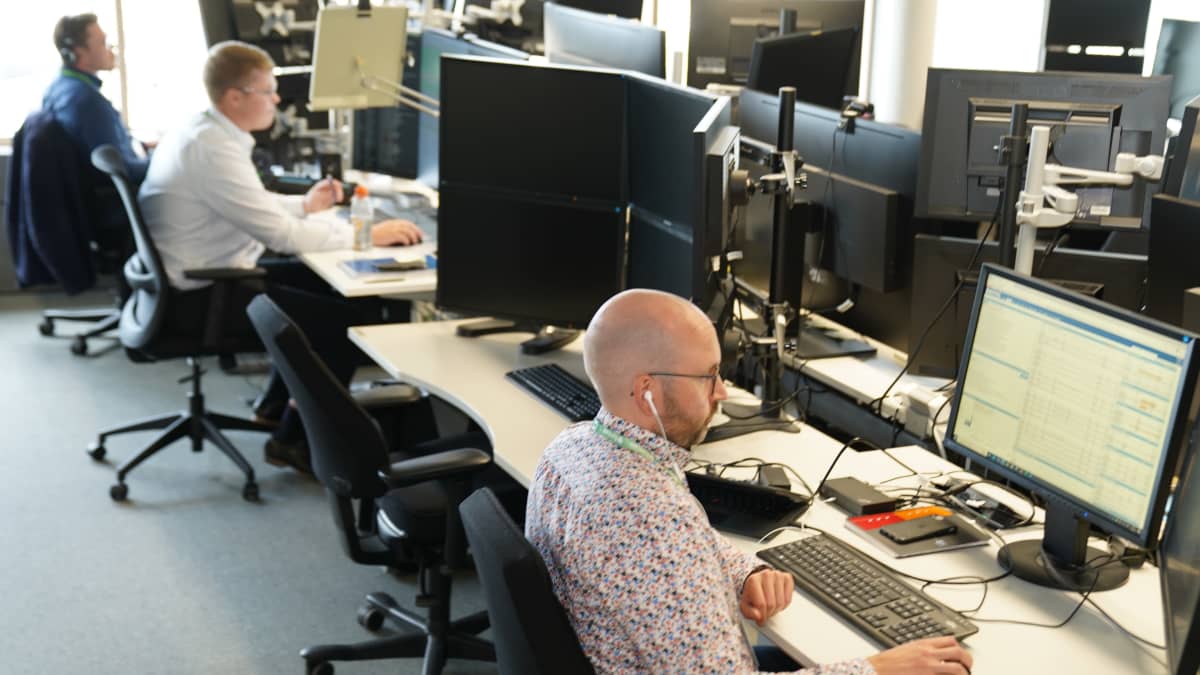 Fortumilla kolme työntekijää tarkkailee monitoreja työpöytiensä ääressä