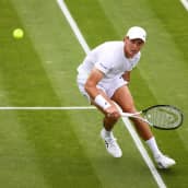 Emil Ruusuvuori palauttaa pallon Wimbledonin tenniskentällä.