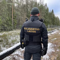 Rajavartija ulkona. Vieressä Suomen ja Venäjän välinen raja. 
