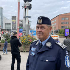 Poliisipomo seisoo aukiolla, ja taustalla näkyy tapahtumaan tulleita ihmisiä 