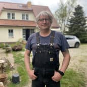 Sven Schattin seisoo talonsa edustalla kädet lappuhaalarien taskussa. 