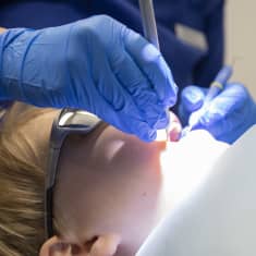 Hammaslääkäri tutkii lapsen hampaita.