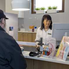 Toivakan apteekkari Marianne Wiiri palvelemassa reseptilääkkeitä noutavaa asiakasta.