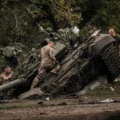 Ukrainalaissotilaita tutkimassa hylättyä venäläistä panssarivaunua.