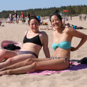 Kaksi naista istuu pyyhkeillä Yyterin hiekkarannalla.