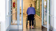 Hoita työntää rullatuolia palveluasumisen hoitoyksikössä.