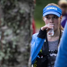 Ultrajuoksija Satu Lipiäinen syö energiapatukkaa.