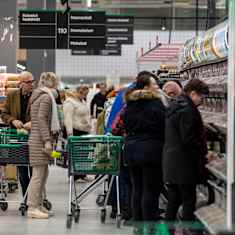 Photo shows shoppers in a supermarket.