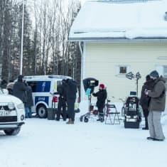 Kuvausryhmä kuvaa kohtausta tv-sarjaa tavisella pihalla, jossa etualalla valkoinen auto ja takas-alalla poliisiauto.
