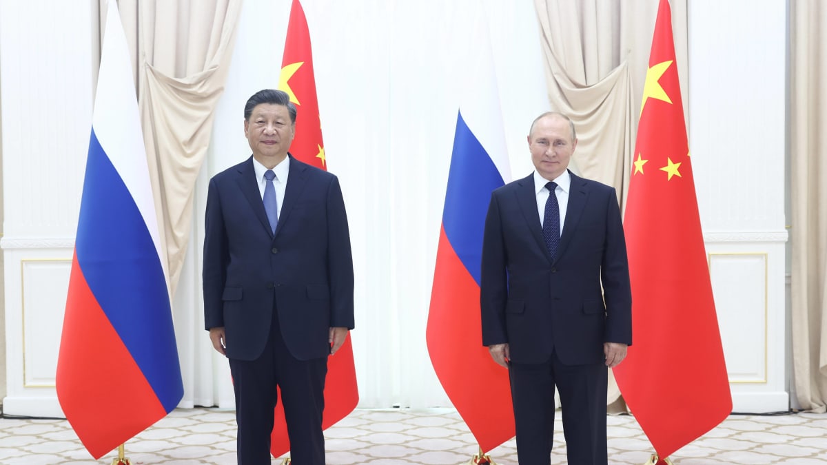 Kokokuvassa Vladimir Putin ja Xi Jinping seisovat vierekkäin. Taustalla Venäjän ja Kiinan lippuja.