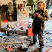 Taiteilija Mikael Arvola käärii tupakkaa varastossaan, missä hän tekee taidetta.