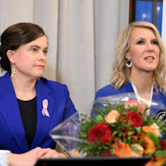 Mari-Leena Talvitie and Sari Multala in blue blazers at a press conference. 