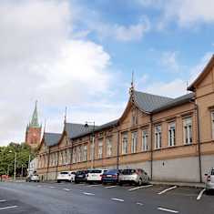 Nystads nya kyrka med högt, spetsigt torn och ett långt gulbrunt hus, där Nystads bibliotek finns.
