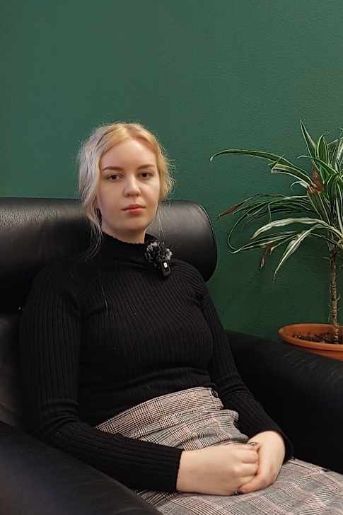 Linda Yrjölä sitter i en stol och tittar mot kameran. 