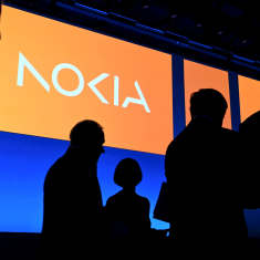 Nokialogotyp med mänskliga silhuetter i förgrunden. 