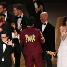 Ihmiset juhlivat Oscar-gaalan lavalla.