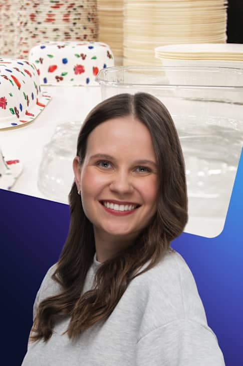 Laura Törnroos står framför en bild på olika förpackningsmaterial.