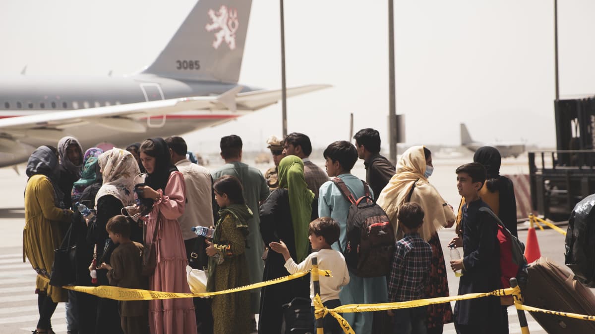 Ihmiset odottavat lentokoneeseen pääsyä Kabulin lentokentällä. 