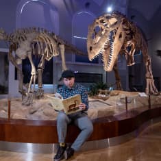 Yleisradion toimittaja Johannes Blom Helsingin Luonnontieteellisessä museossa, kädessään Dougal Dixonin klassinen tietokirja "Ihmisten jälkeen".
