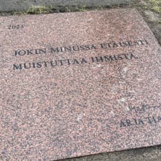 Kivilaatassa lukee Arja Tiaisen runo: Jokin minussa etäisesti muistuttaa ihmistä.