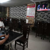 Ihmiset katsovat Imran Khanin puhetta televisiosta ravintolassa Islamabadissa.
