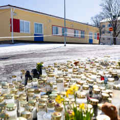 Kukkia ja kynttilöitä Viertolan koulun ulkopuolella.