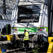 Työntekijä pesi veturin etulasia Helsingin päärautatieasemalla kesäkuussa.