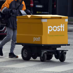 Postin kuljettajia suojatiellä.