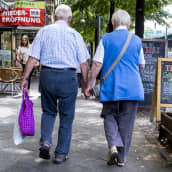 Vanha saksalainen pariskunta kävelee kadulla käsi kädessä.