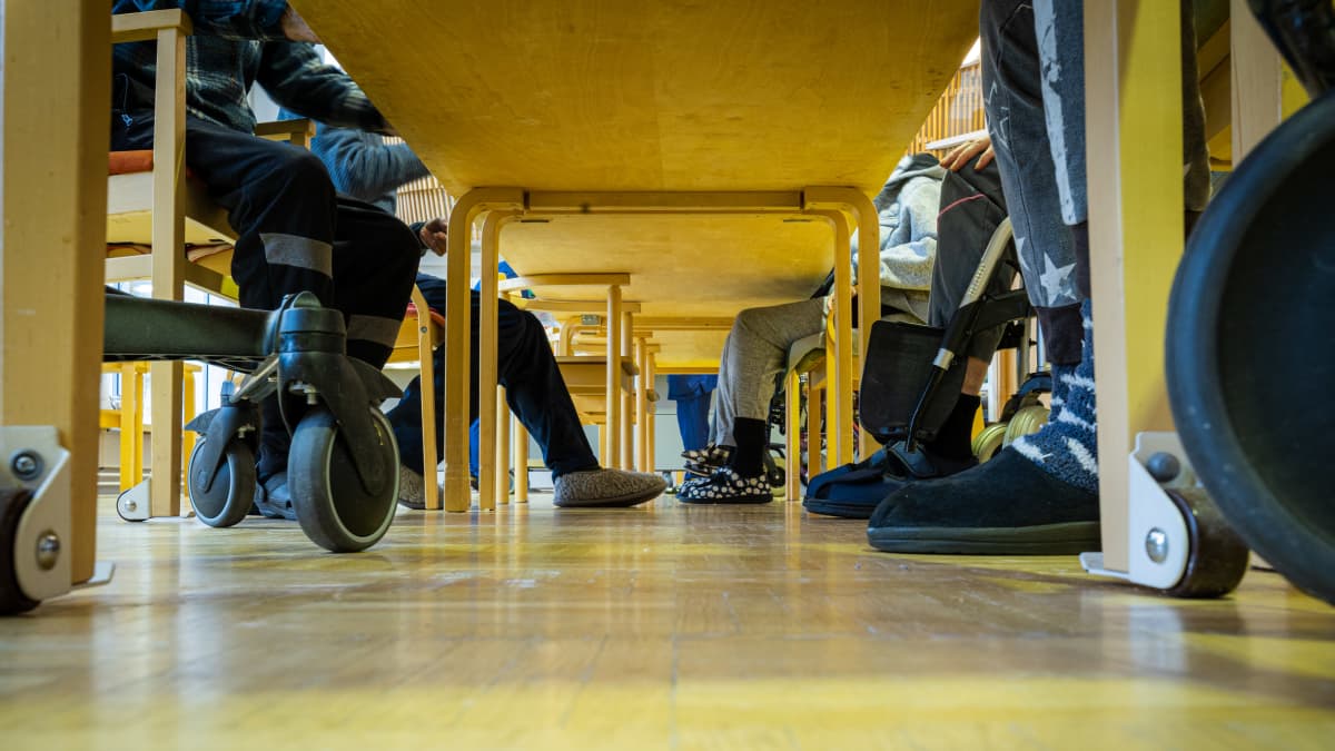 Vanhusten jalkoja pöydän alla Vaarinsaaren hoivakodissa Mikkelissä.