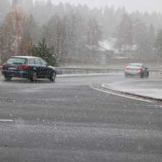 Photo shows a car driving on a snowy road.