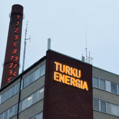 Turku Energian nimikyltti loistaa rakennuksen seinässä alkuillasta.