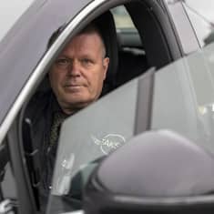 Kouvolan taksiautoilijat ry:n puheenjohtaja Marko Häkkinen istumassa taksissaan.