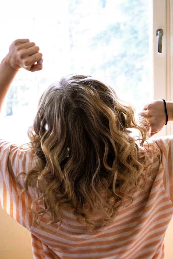 nuori nainen ikkunan edessä aamulla virkeänä.